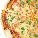 Cauliflower Pizza crust with sauce and cheese.