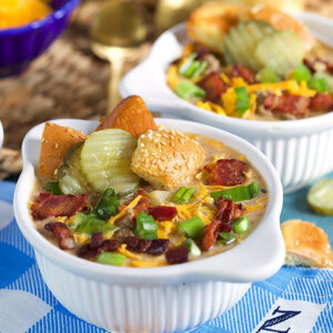 Bacon Cheeseburger Soup recipe in a white bowl on a blue and white checked napkin.