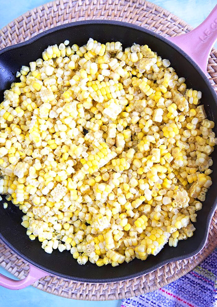 Sweet corn in a pink cast iron skillet