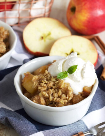 Apple Crisp in a white ramekin with ice cream on top