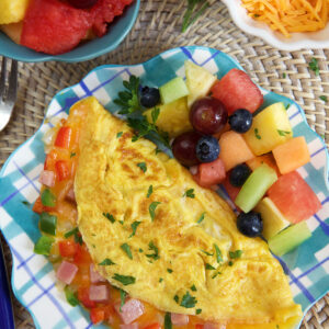 An omelette and fruit are on a plate.