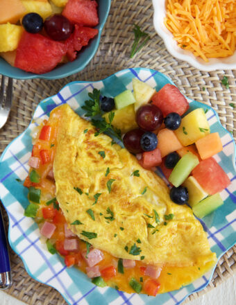 An omelette and fruit are on a plate.