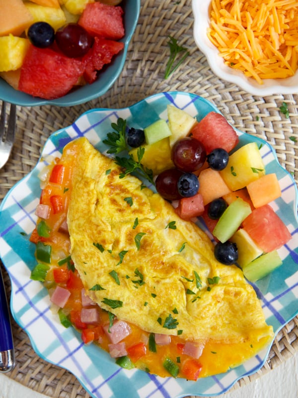 An omelette and fruit are on a plate.
