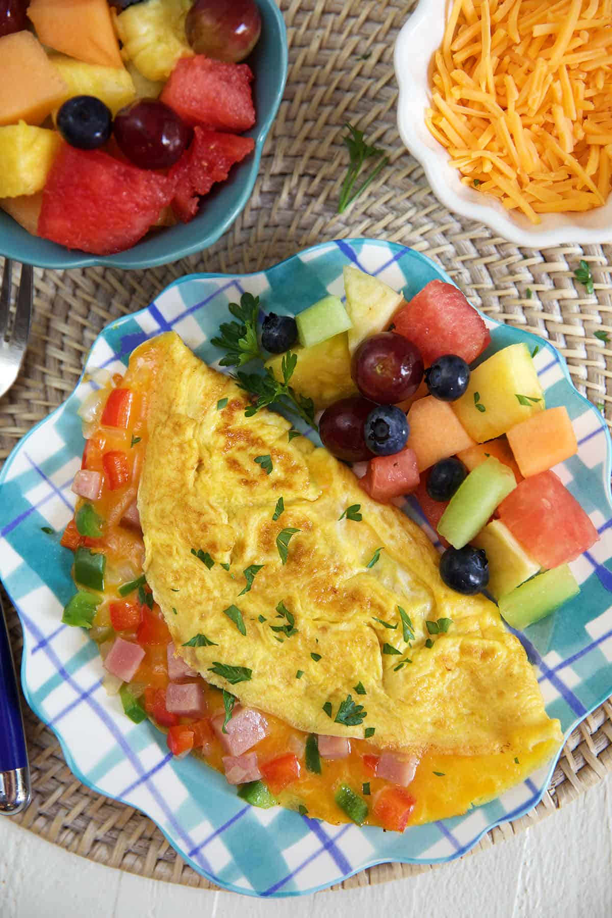 An omelette and fruit are on a plate. 