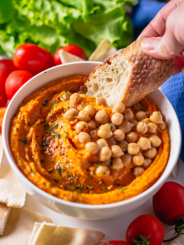 Bread is being dipped into the hummus.