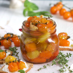 A jar of tomato confit is on a white surface.