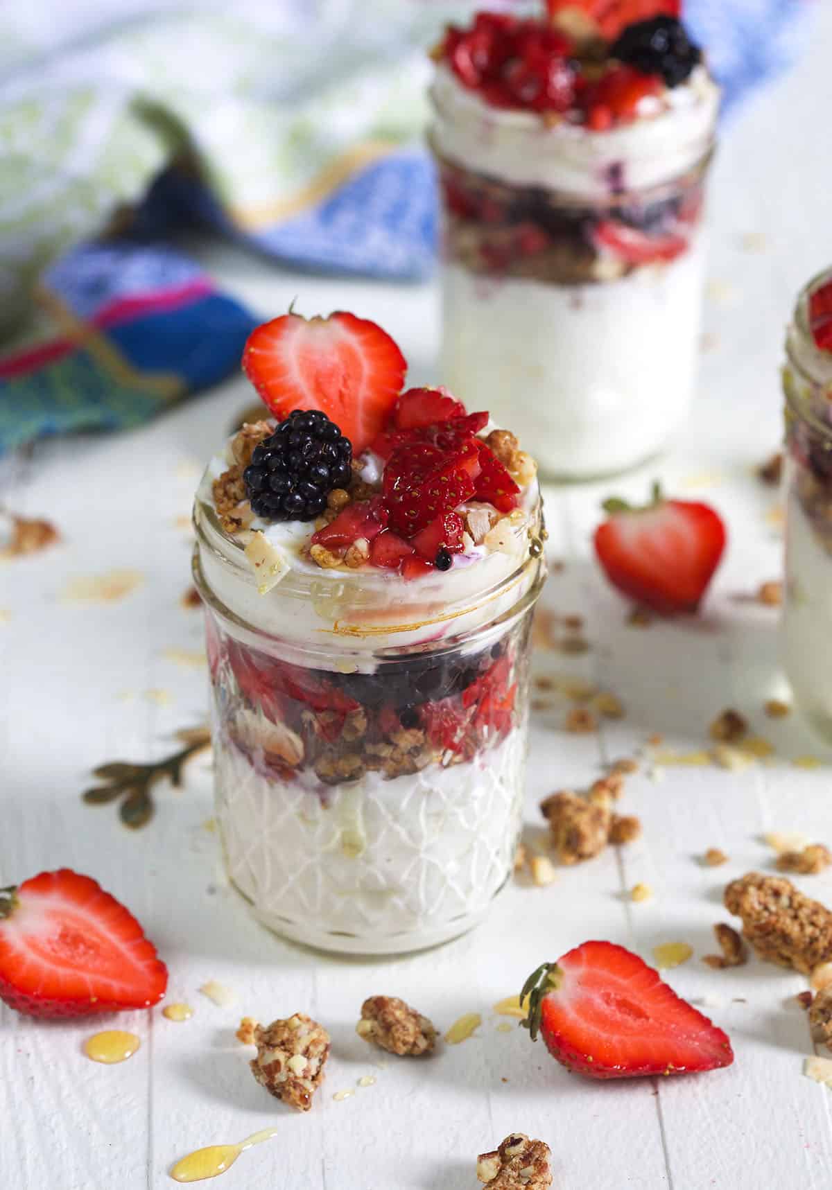 Two jars filled with parfait are placed on a white surface. 