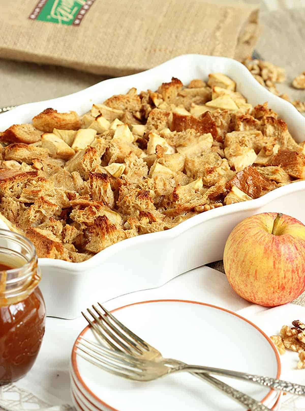 caramel apple bread pudding in a white casserole dish.