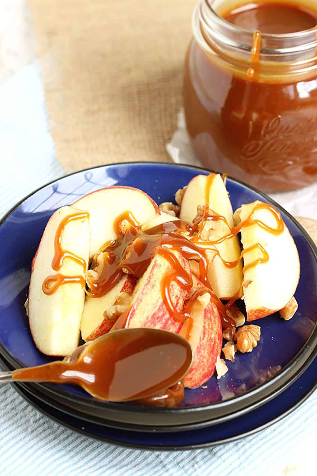 A plate with sliced apples drizzled with caramel sauce