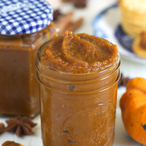 A jar is filled to the brim with pumpkin butter.