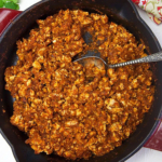 Sofritas are being cooked in a large black skillet.