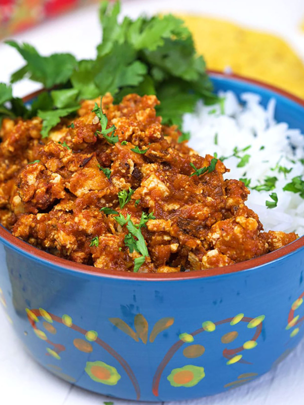 A blue bowl is filled with rice and sofritas.