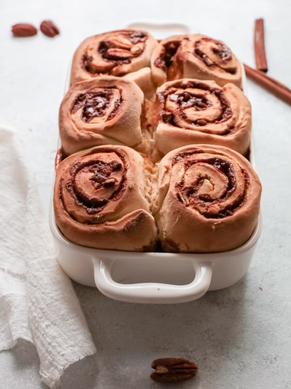 A white pan is filled with baked cinnamon rolls.