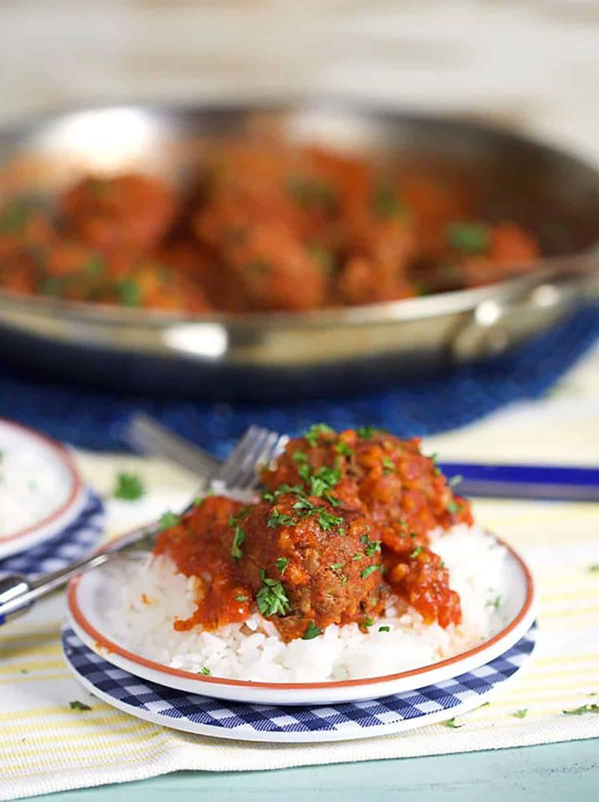 Porcupine meatballs on a white plate with rice.