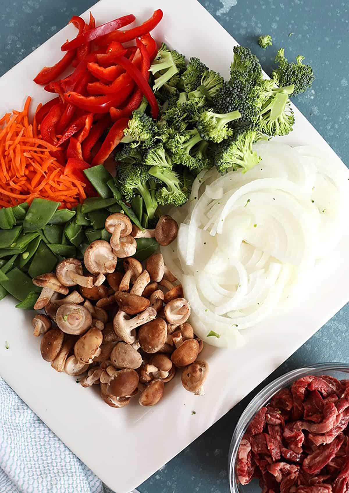 vegetables for beef stir fry on a white platter.