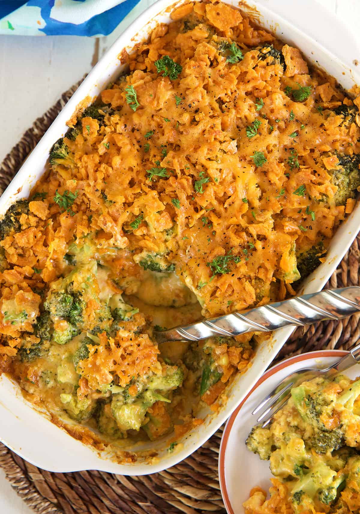 A silver spoon is placed in baked broccoli cheese casserole.