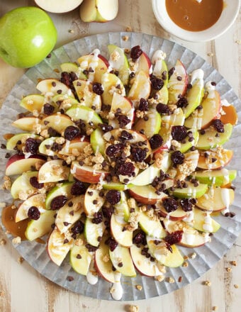 Caramel Apple Nachos arranged on a steel platter on a wood board