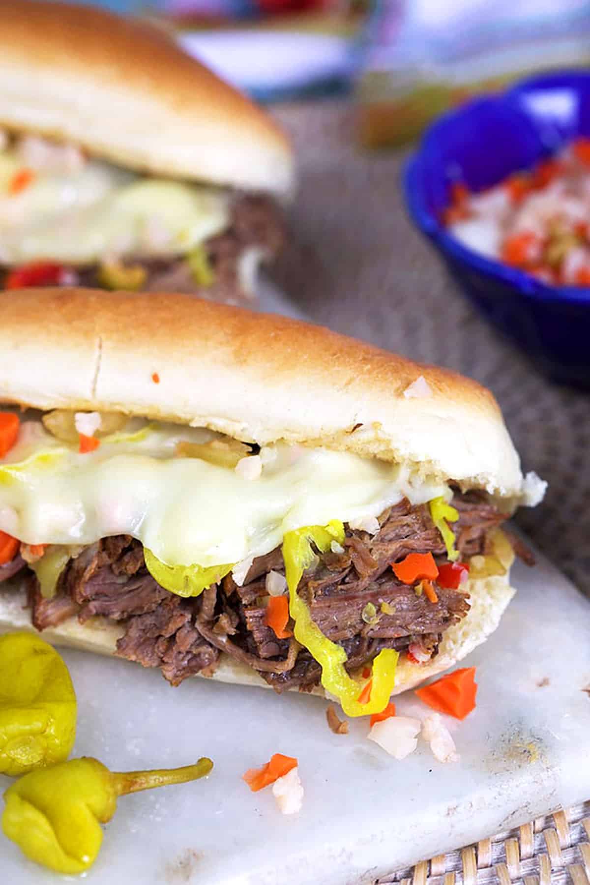 Close up of shredded italian beef on a long roll.