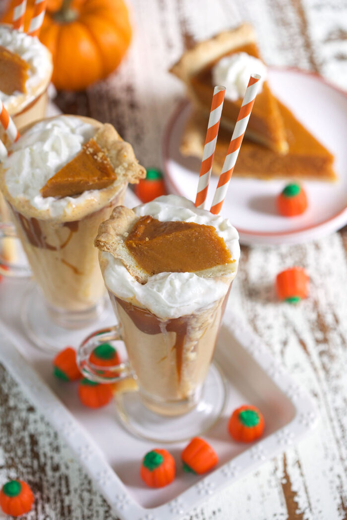 A few milkshakes are topped with whipped cream and tiny slices of pumpkin pie.