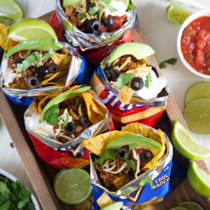 Several chip bags are filled with taco ingredients.