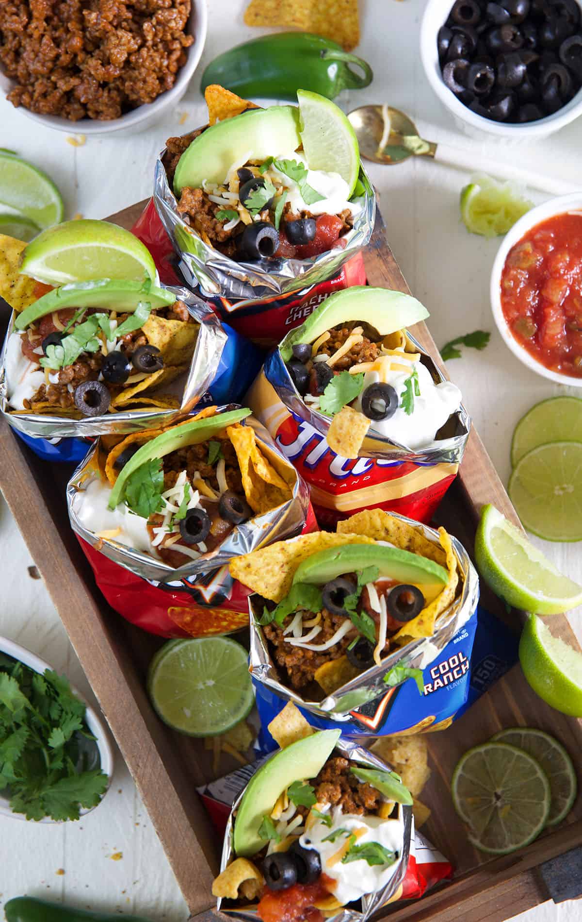 Several chip bags are filled with taco ingredients. 
