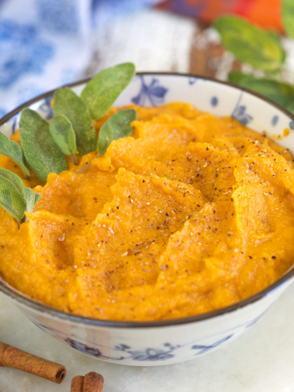 A bowl filled with puree is garnished with fresh greens.