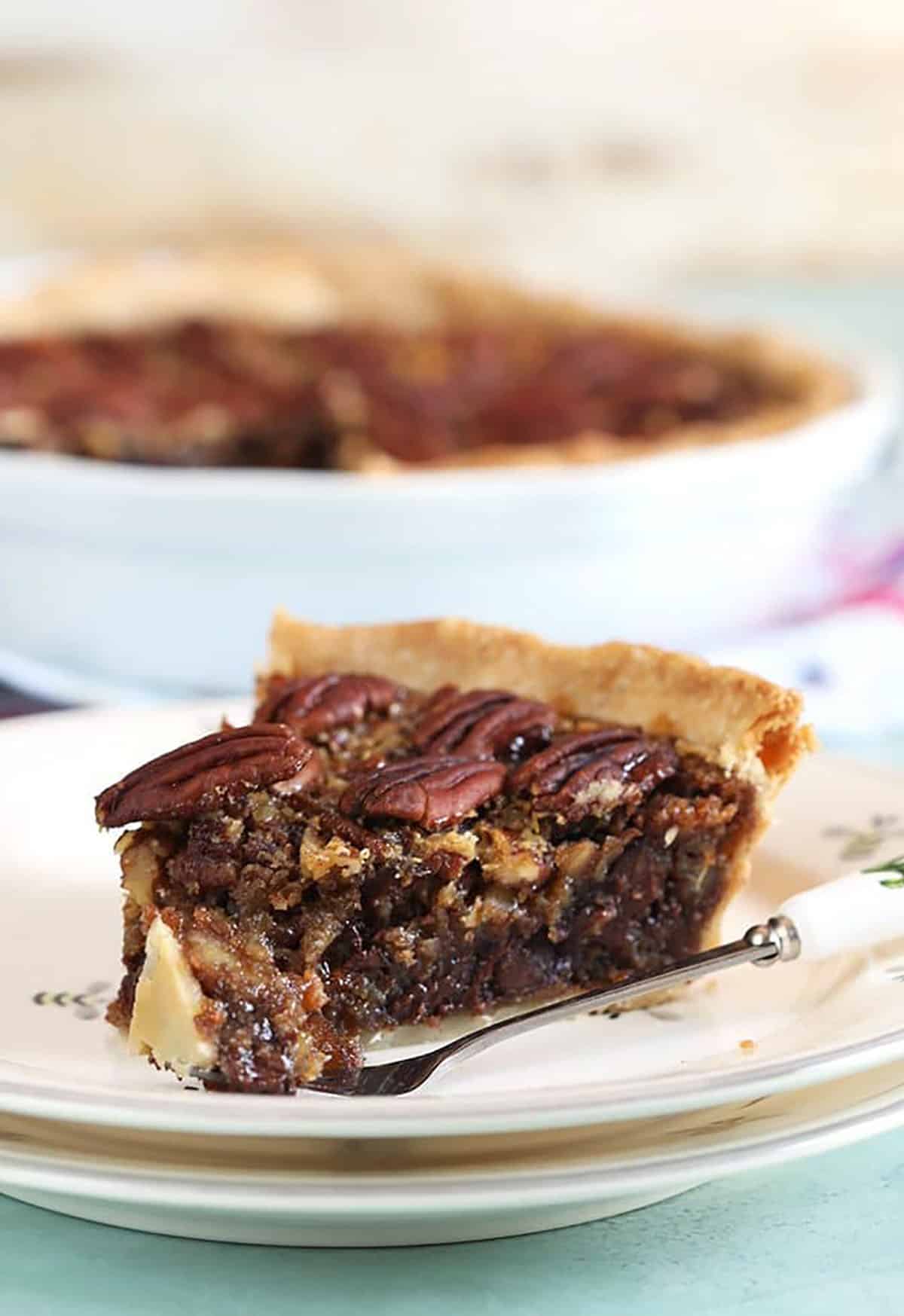 Close up of pecan pie with a bite taken off with a fork.