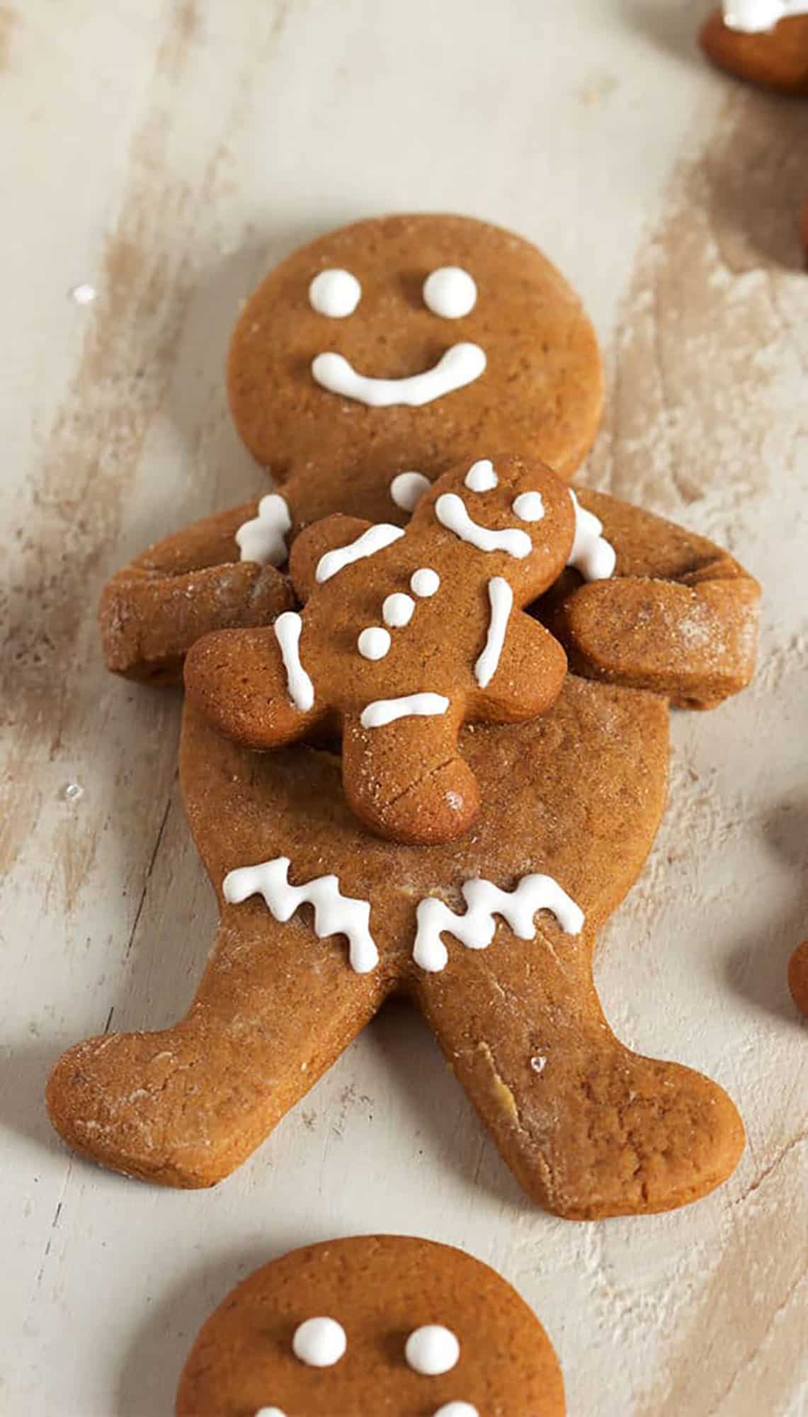 Gingerbread man cookie holding a small gingerbread cookie.