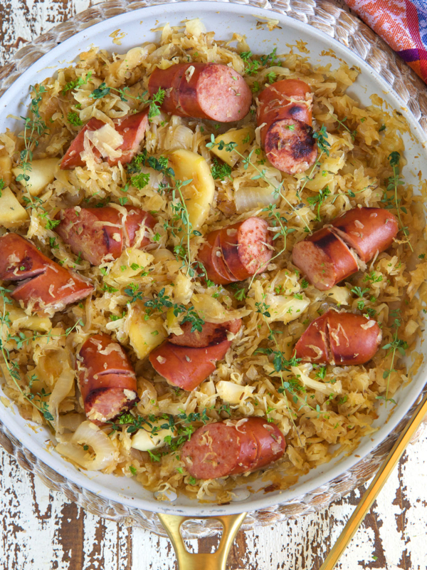 A large pan is filled with kielbasa and saurkraut.