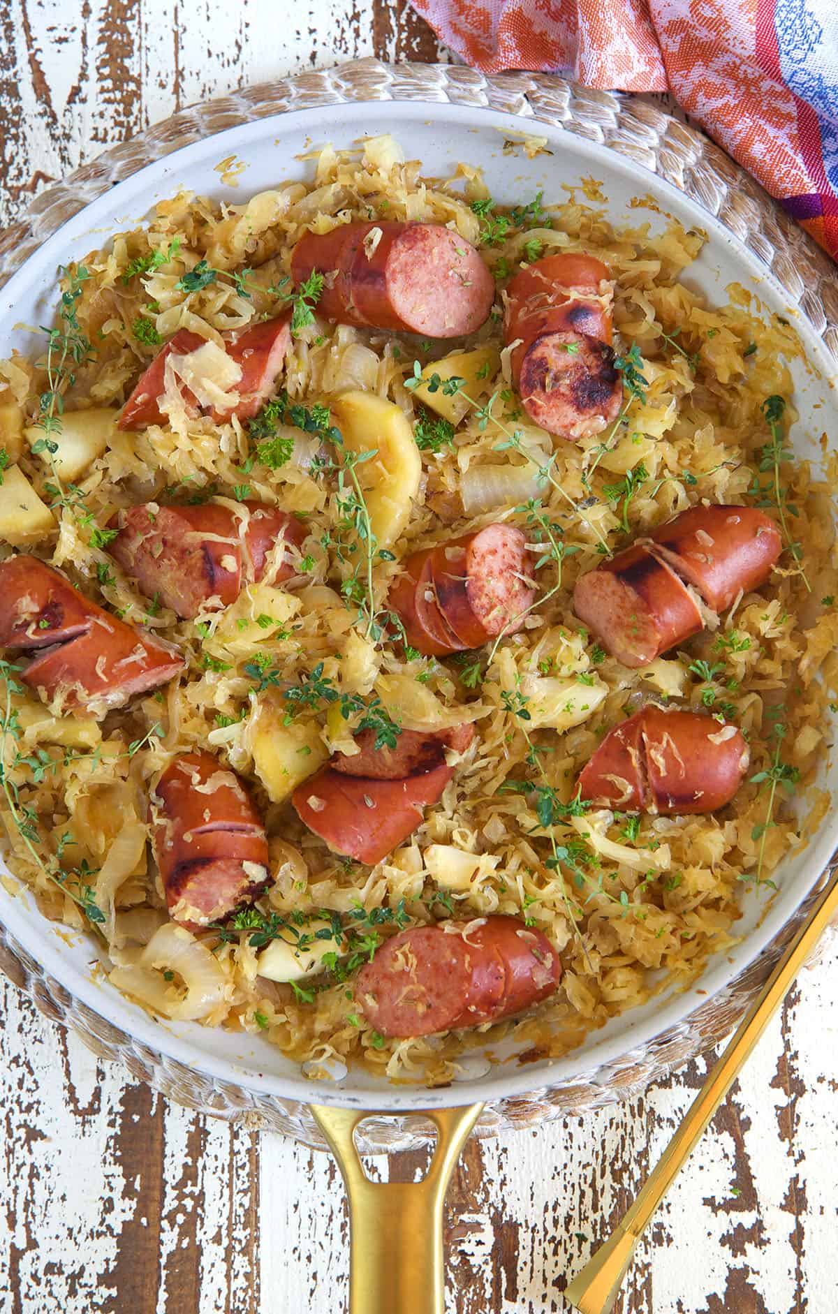 A large pan is filled with kielbasa and saurkraut. 
