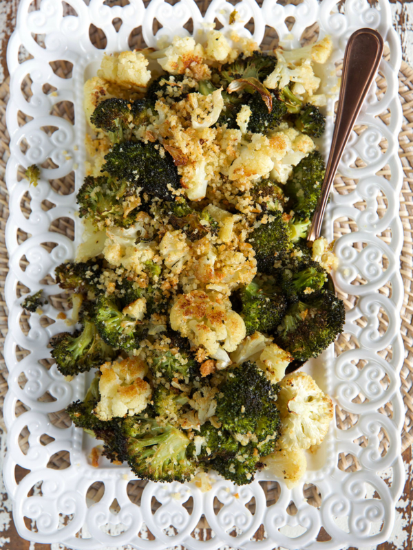 A large portion of roasted broccoli and cauliflower is presented on a white serving tray.