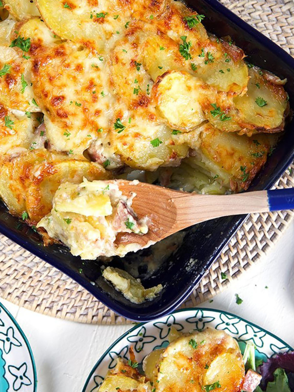 Overhead shot of scalloped potatoes and ham casserole in a baking dish.