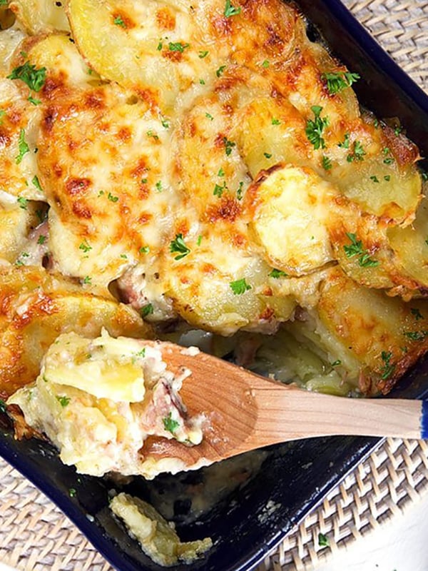 Overhead shot of scalloped potatoes and ham casserole in a baking dish.