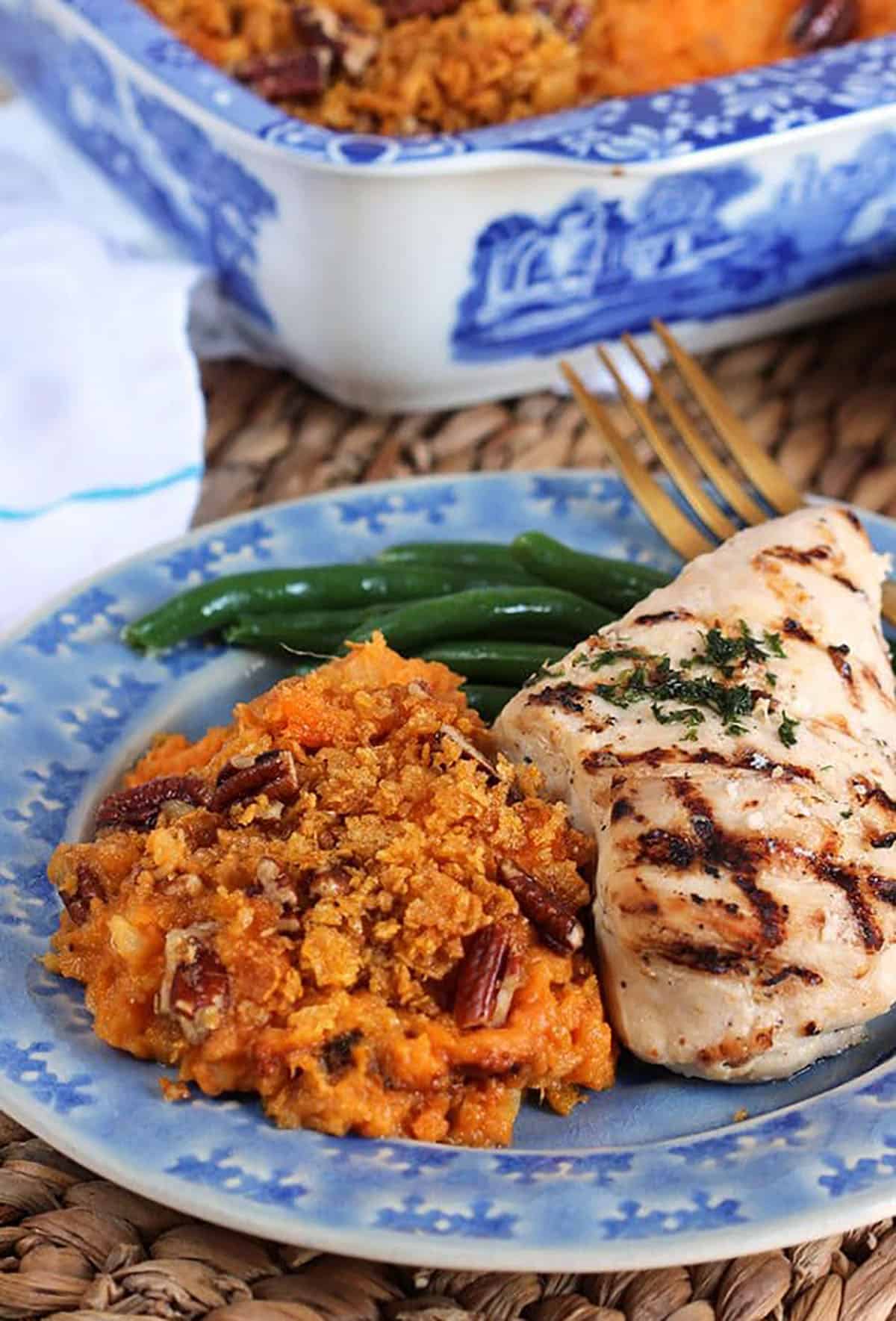 Sweet Potato Casserole on a blue plate with a piece of grilled chicken breast.