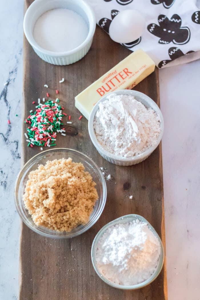 The ingredients for the funfetti cookies are placed on a wooden surface. 