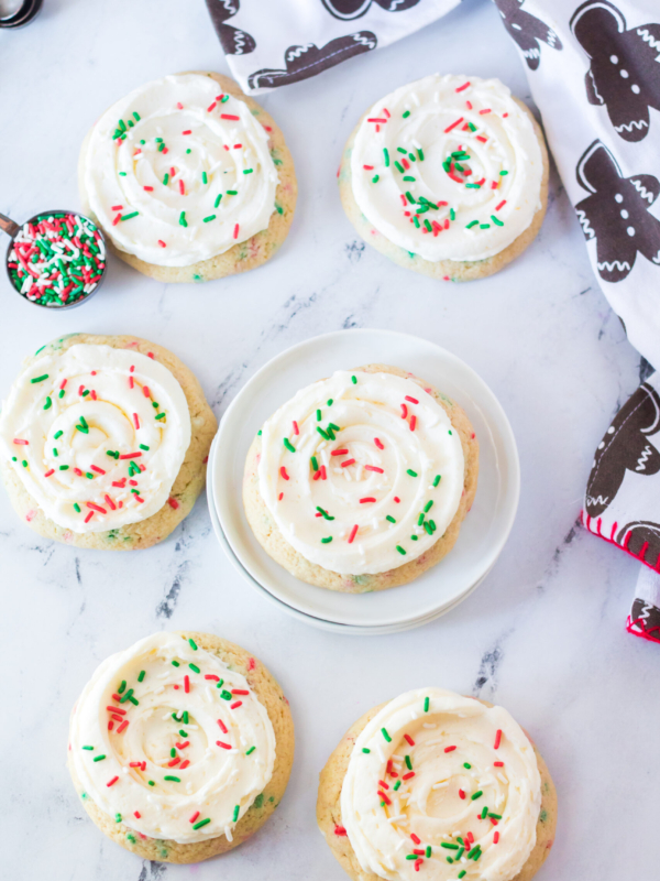 Six iced sugar cookies are topped with red and green sprinkles.
