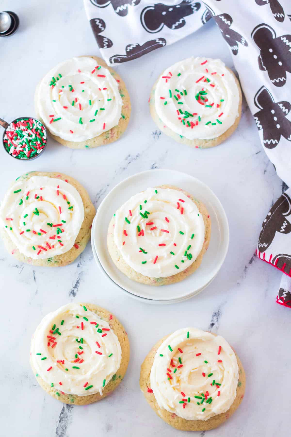 Six iced sugar cookies are topped with red and green sprinkles.