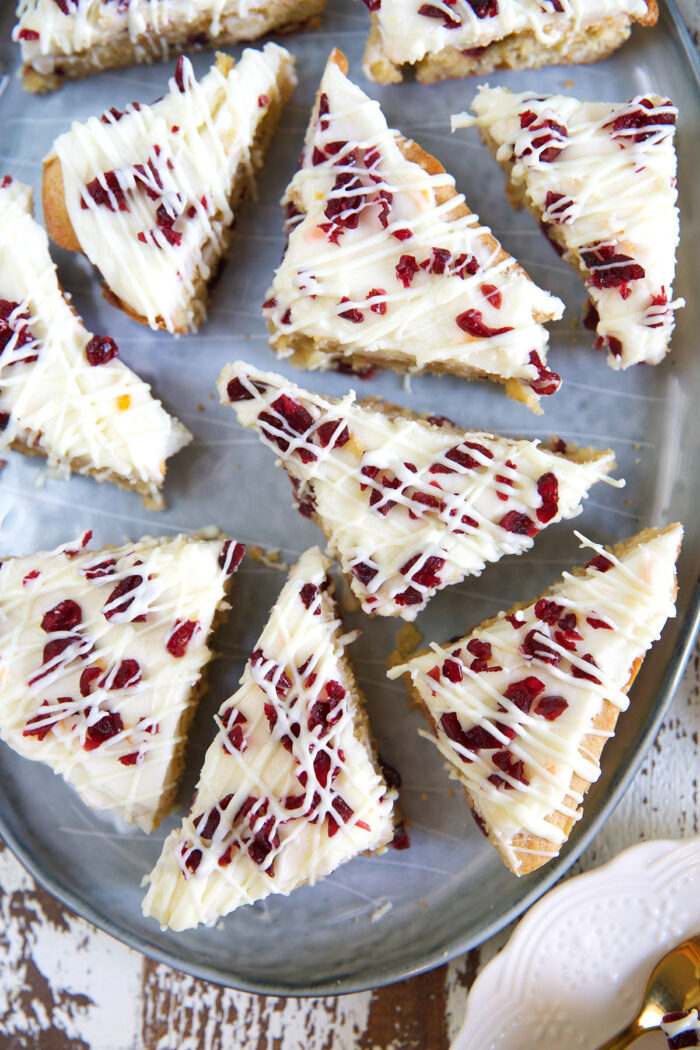 Several cranberry bliss bars are presented on a silver serving tray.