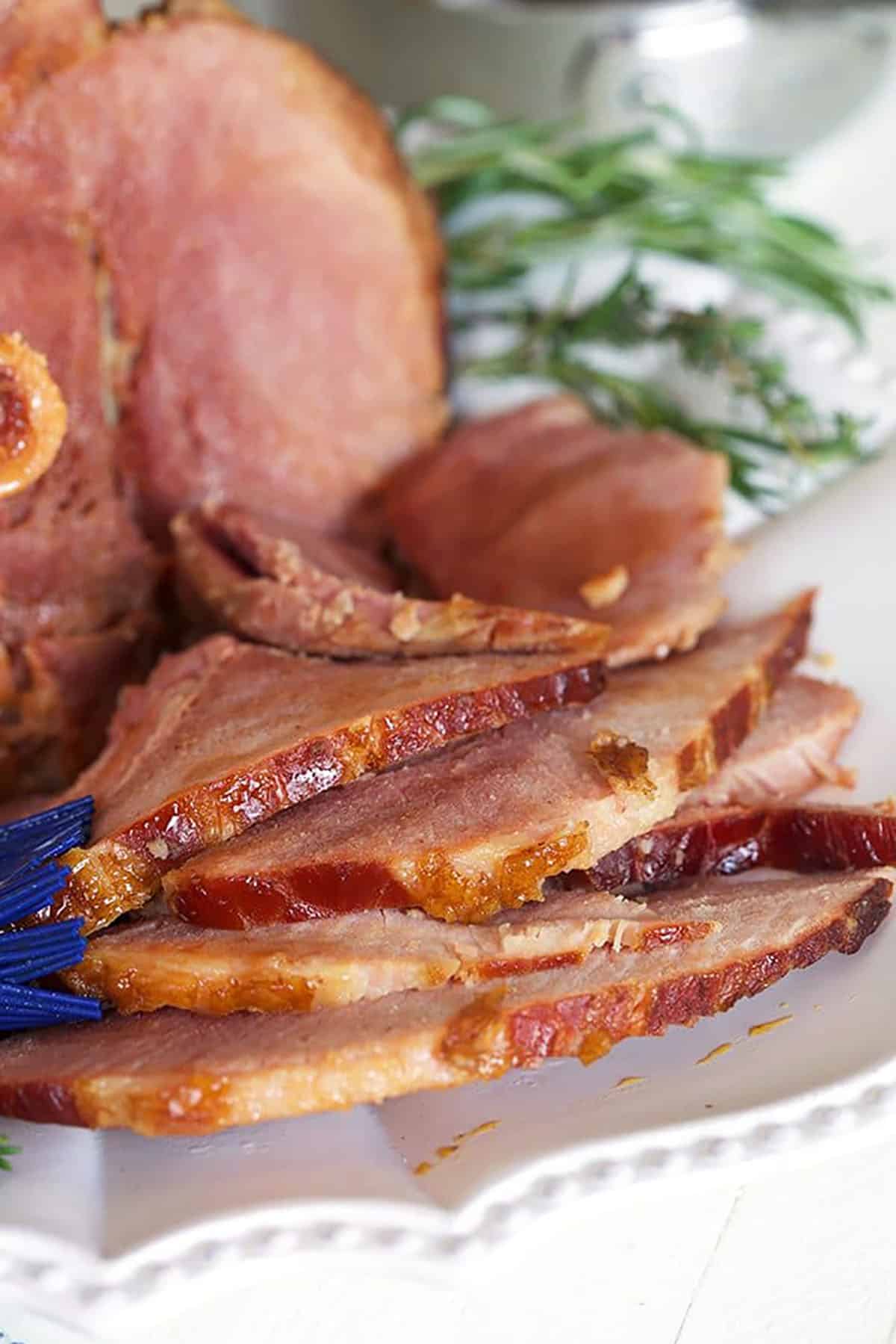 slices of honey glazed ham on a white platter