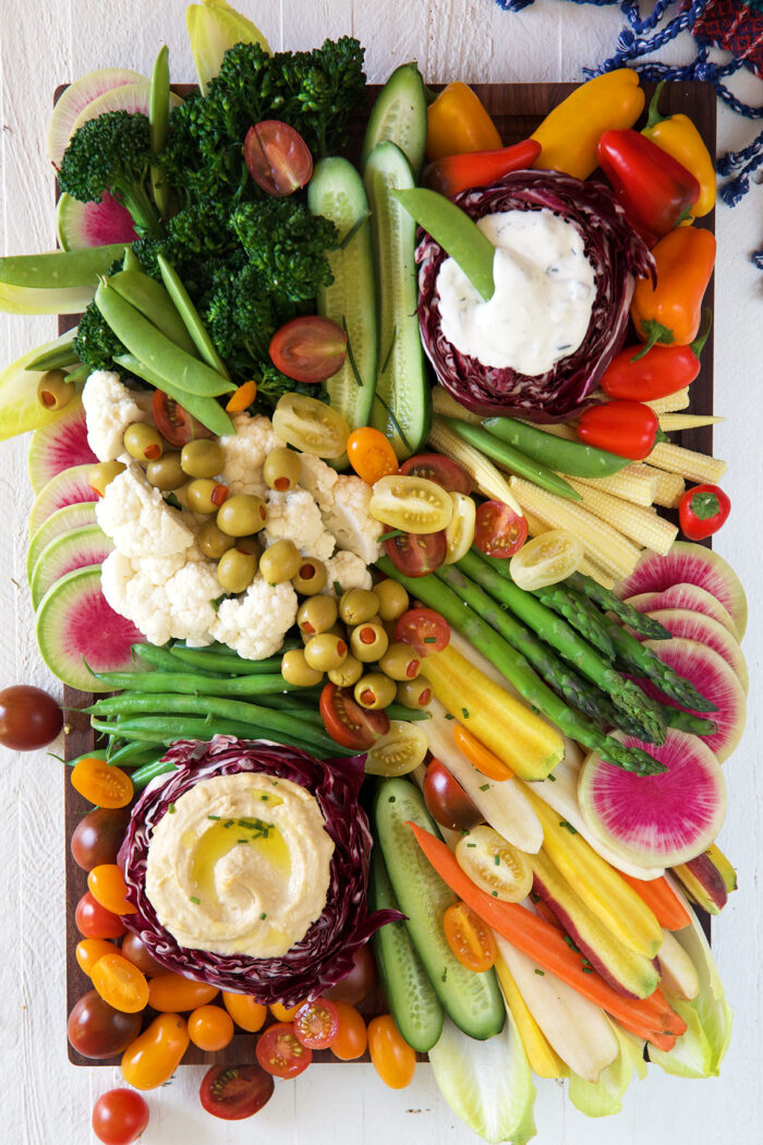 A large rectangular platter is filled entirely with veggies and dips.