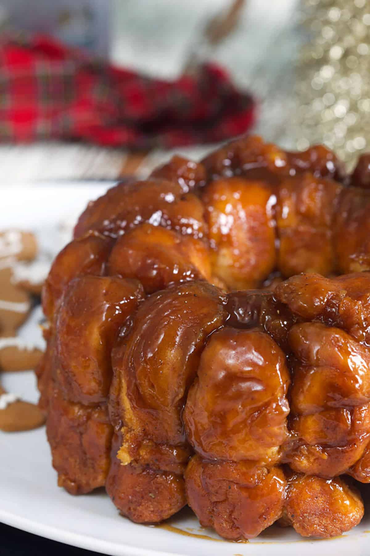 Baked monkey bread is presented on a round white serving platter.