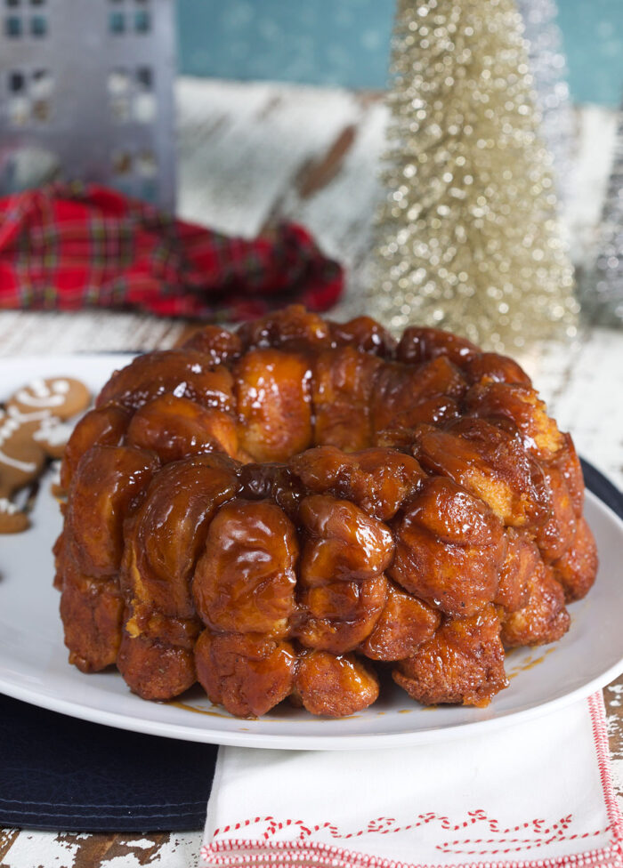 A ring of baked monkey bread on a white platter is ready to eat.