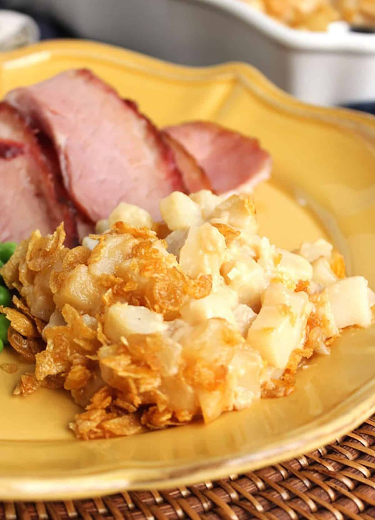 Hash Brown Casserole on a plate with ham slices