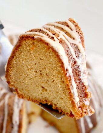 A slice of pound cake is being lifted from the rest of the cake.