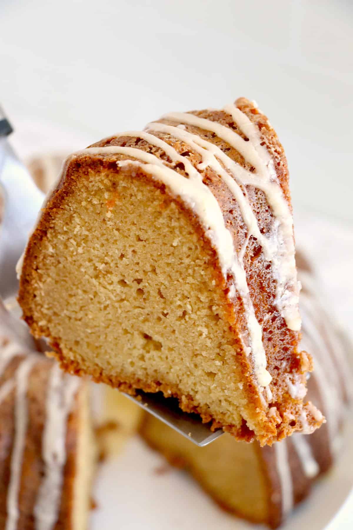 A slice of pound cake is being lifted from the rest of the cake.