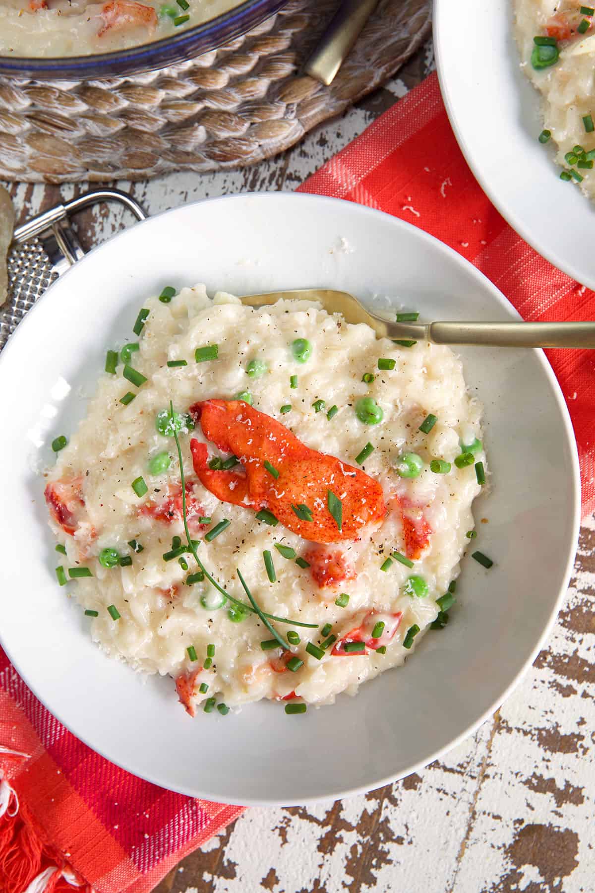 A bowl of lobster risotto is topped with claw meat.