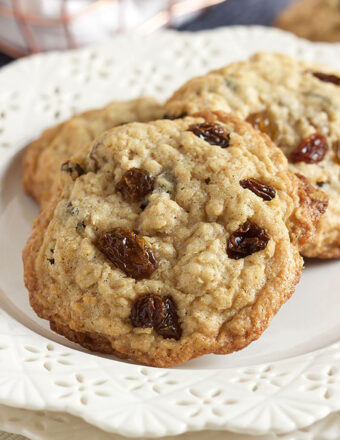 Oatmeal raisin cookies stacked on a white plate.