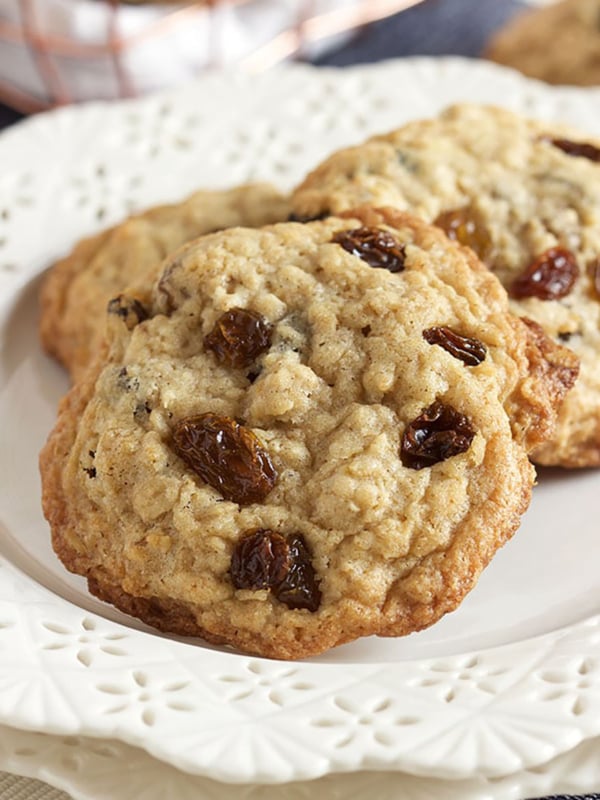 Oatmeal raisin cookies stacked on a white plate.