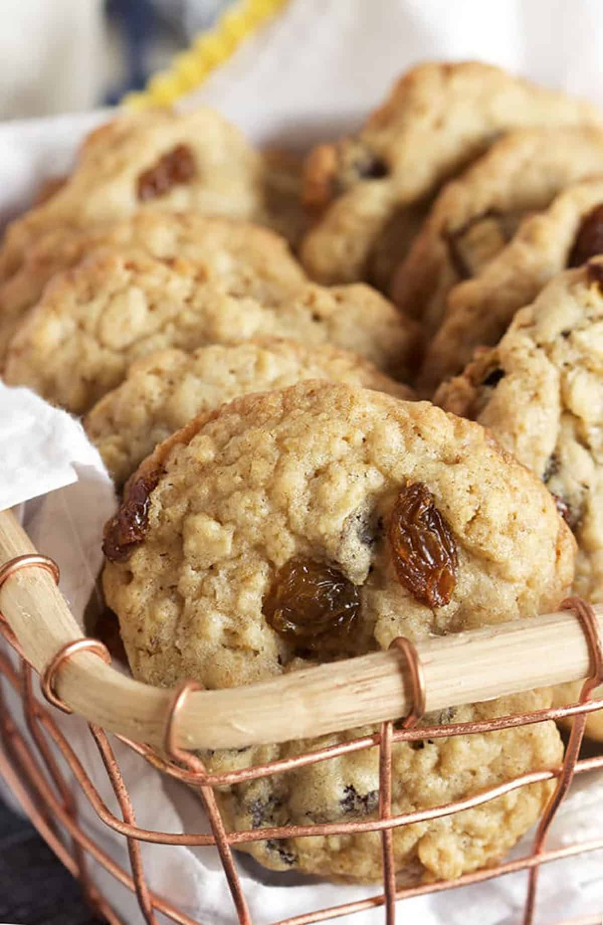 Oatmeal raisin cookies arranged in a basket lined with a white linen.