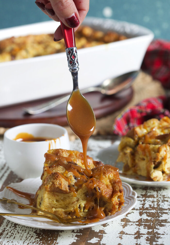 Caramel sauce is being drizzled ontop a single serving of bread pudding.
